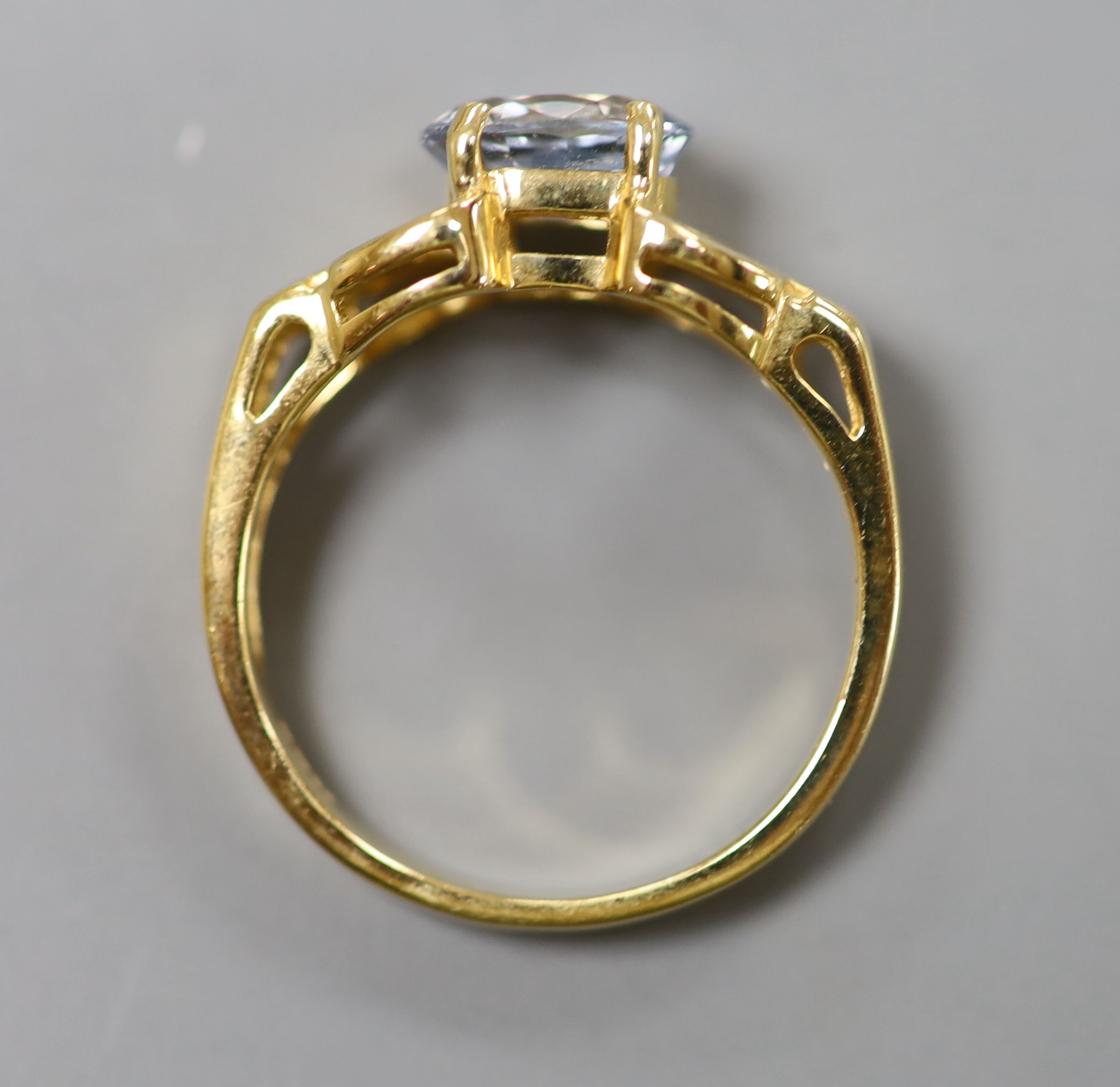 A pale aquamarine ring, pierced 18ct gold setting and shank and an 18ct gold and pale sapphire ring
